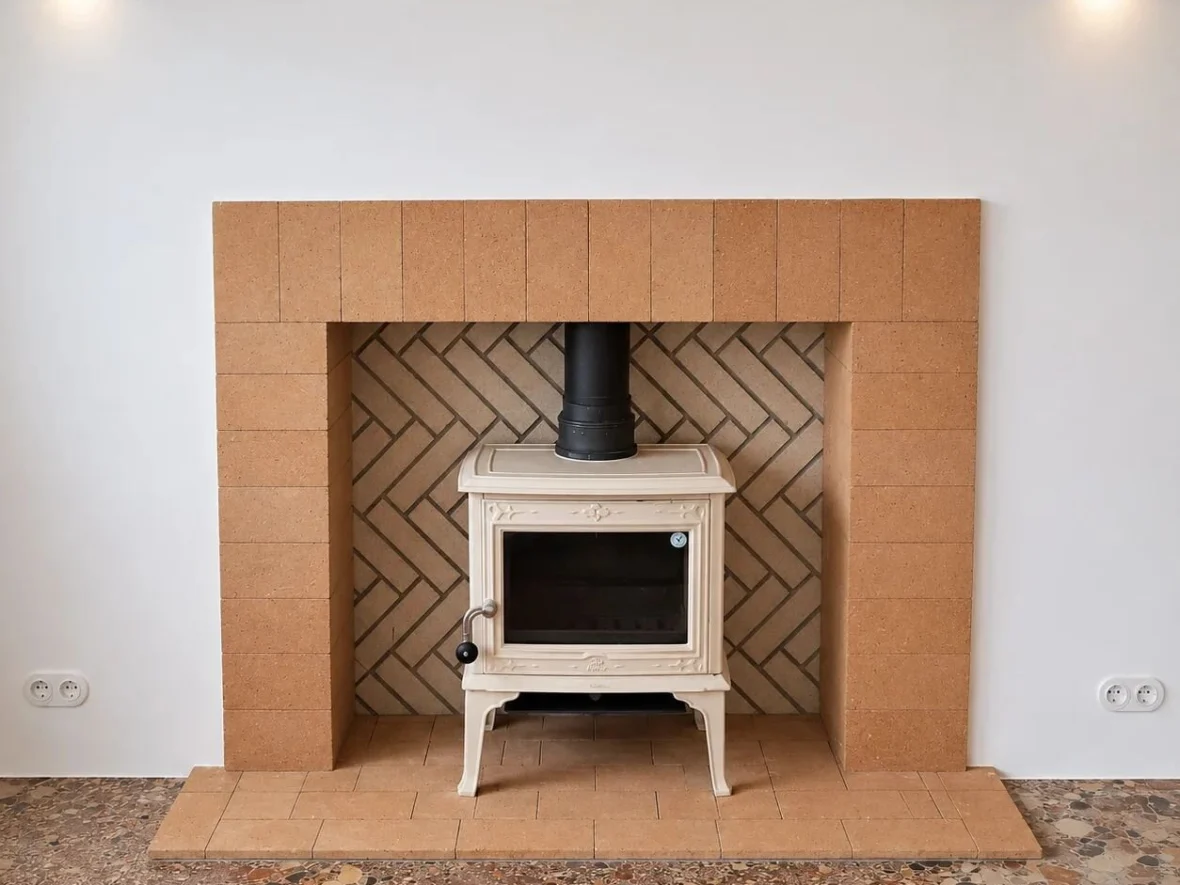 After — dressed stone fireplace, with a brick firebox laid in herringbone over encaustic tiles