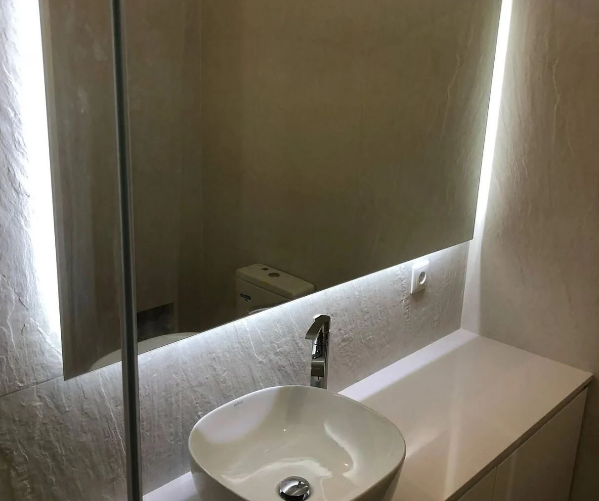 Stone vanity top with a back-lit mirror