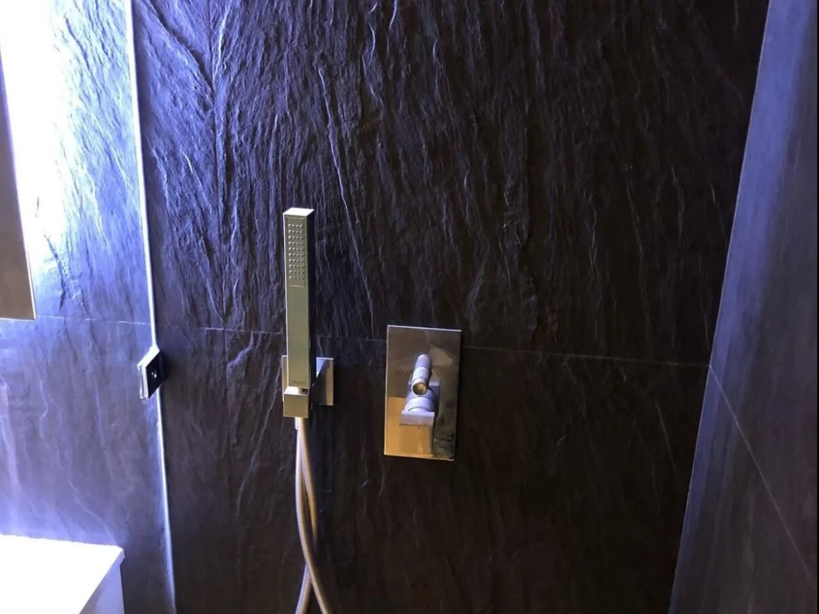 Shower lined throughout in dark stone