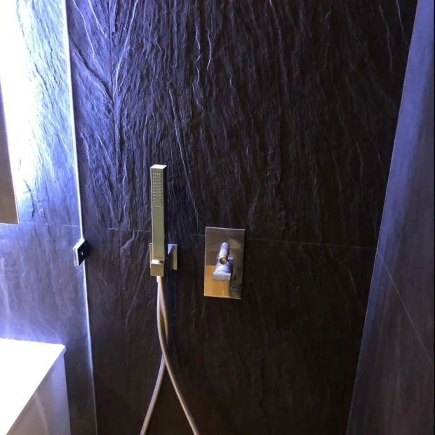 Shower lined throughout in dark stone