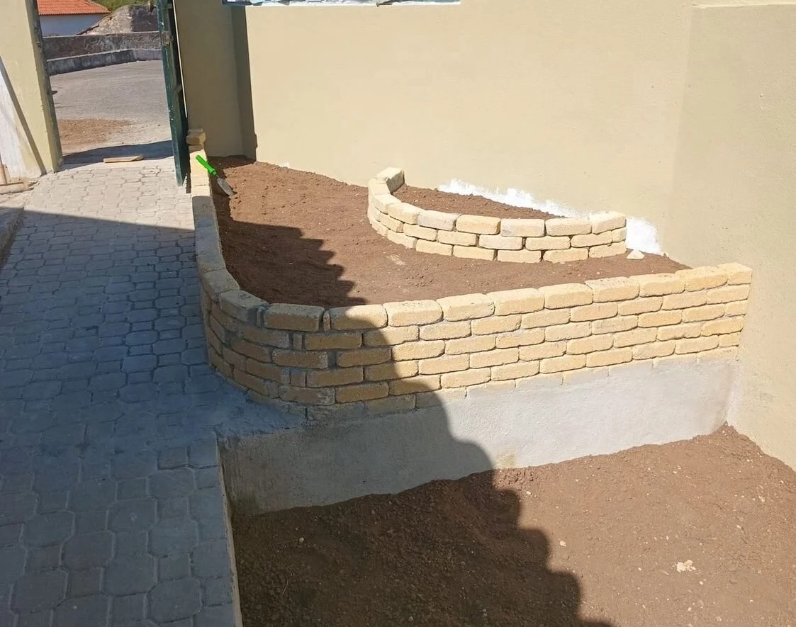 After — stone masonry planters and a cobbled surface