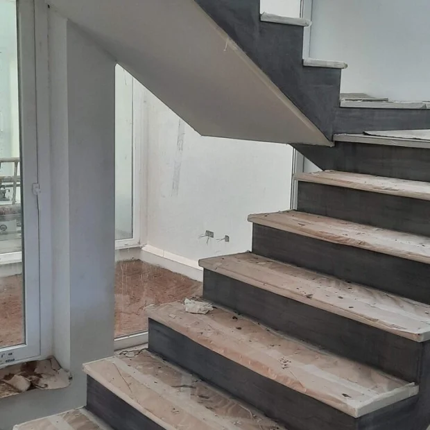 Stair under construction: timber treads on a clad structure