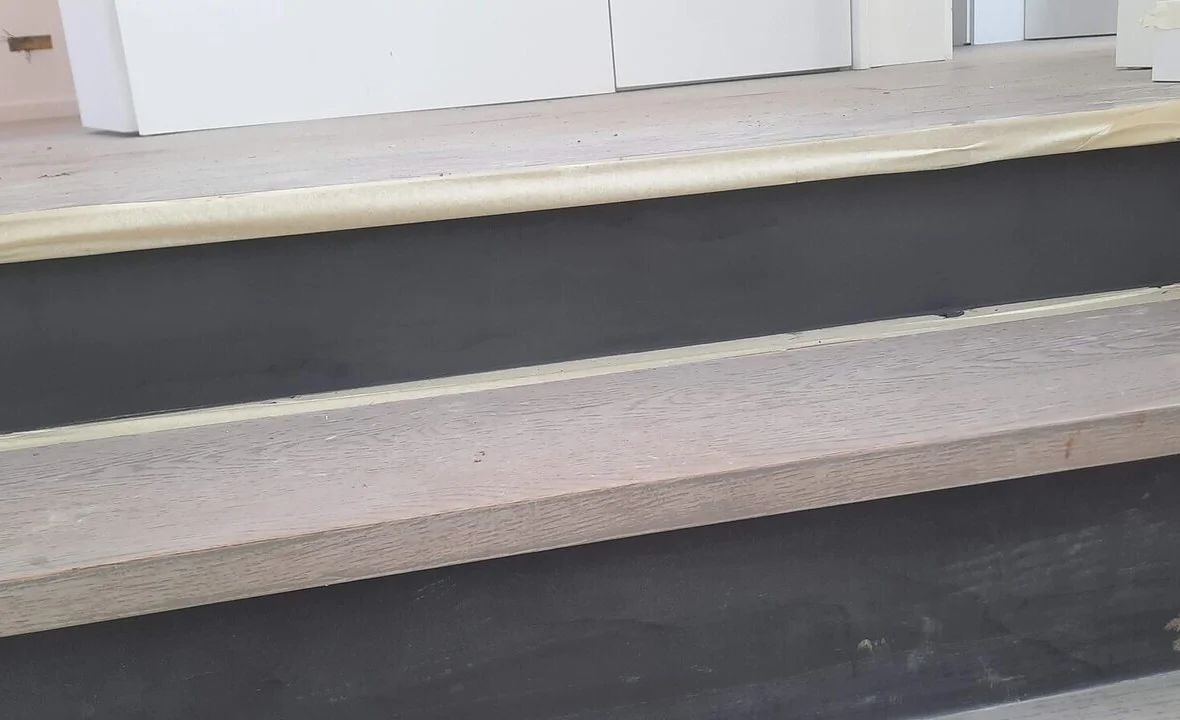 Stair finished: timber treads and dark microcement