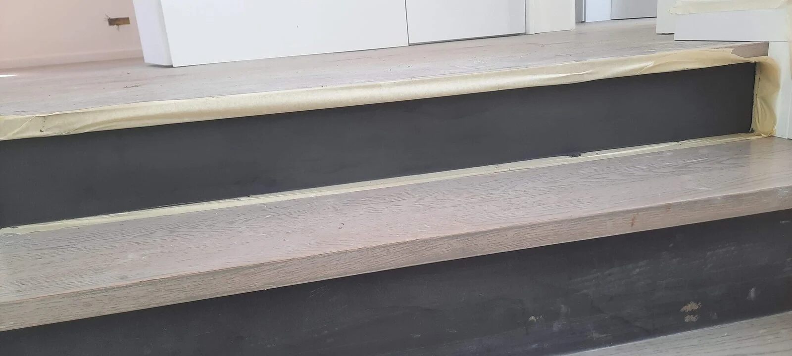 Stair finished: timber treads and dark microcement