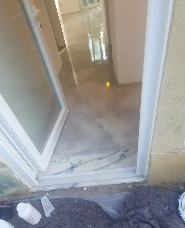 Microcement floor beside a glazed opening